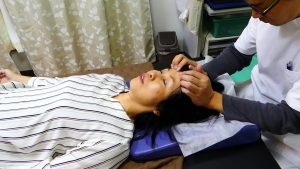 おでこの骨前頭骨を軽く押さえながら上に引き上げていく