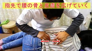 触圧覚刺激法：指先で腰の骨と皮膚を広げていく