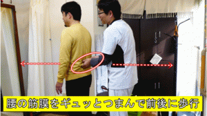 腰の筋膜をギュッとつまんで前後に歩行